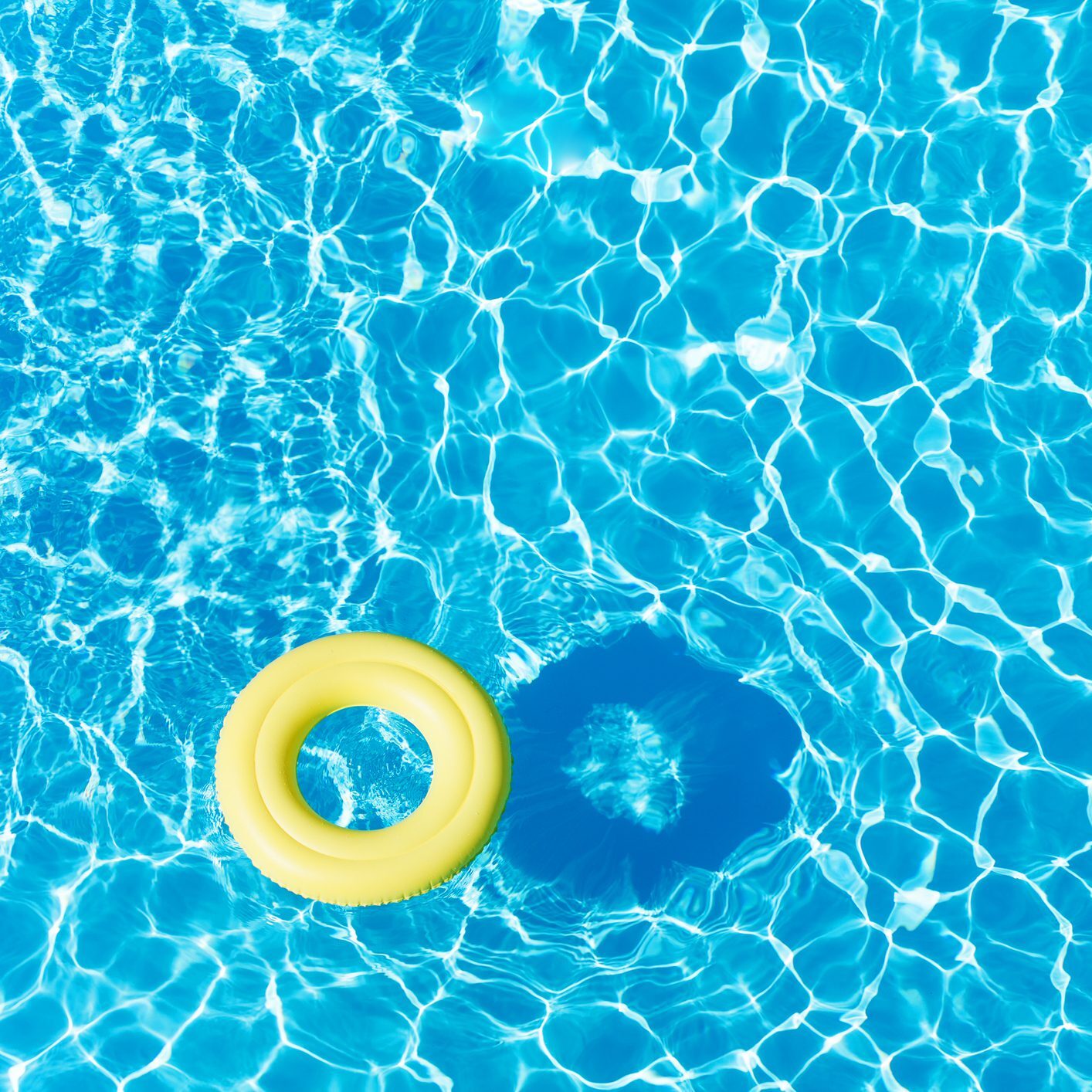 Anneau de caoutchouc vide flottant à la surface de l’eau bleue